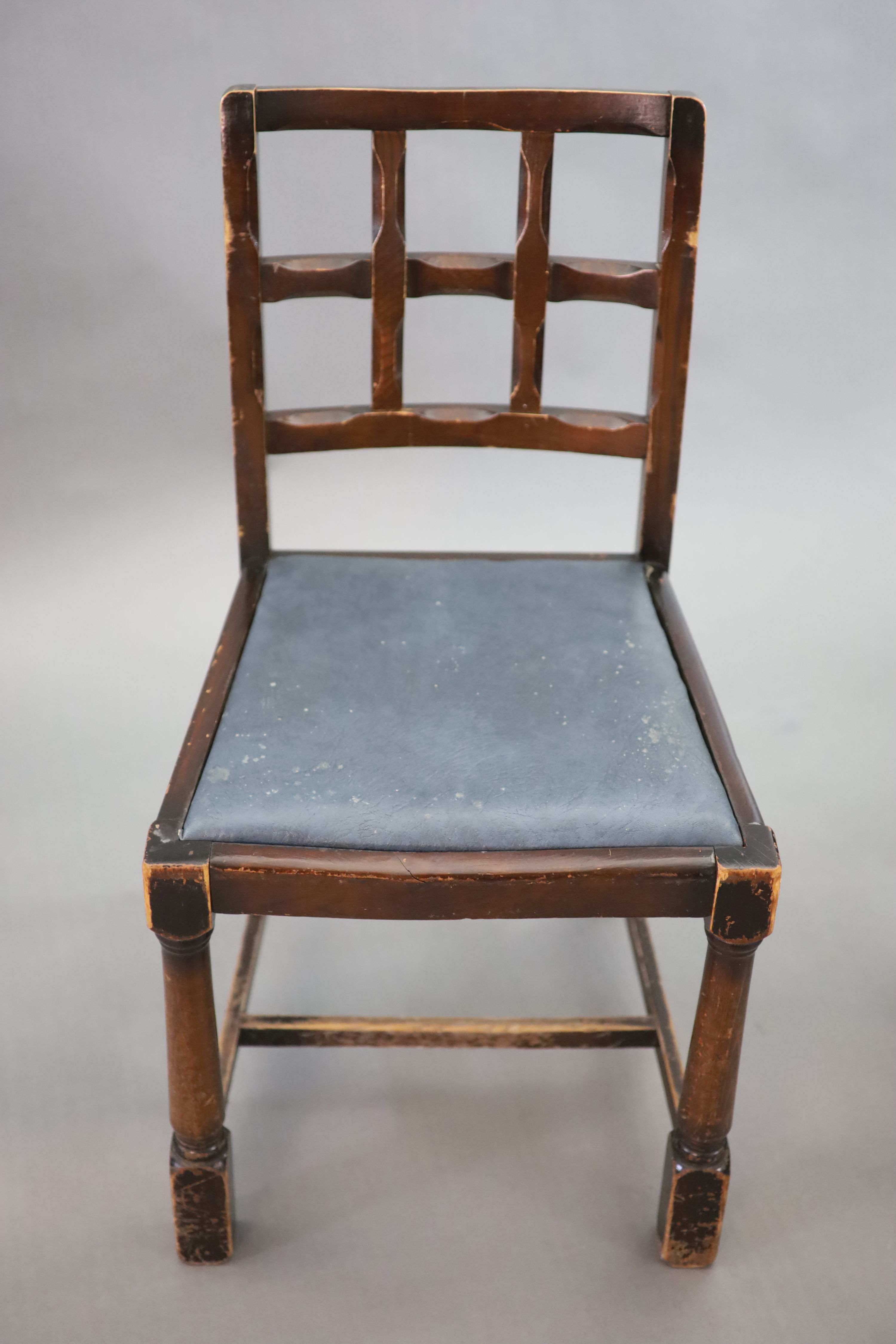 A set of twelve stained beech and oak dining chairs, with cross frame backs and drop-in seats, on turned and squared legs